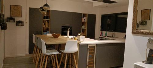 - une cuisine avec une table en bois et des chaises blanches dans l'établissement Villa élégante et chaleureuse proche de Paris, à La Frette-sur-Seine