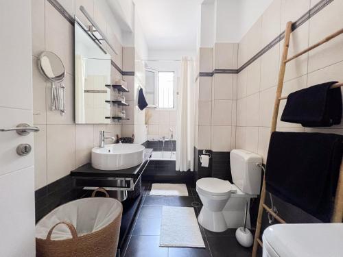 a white bathroom with a sink and a toilet at My Porto Villa in Porto Rafti