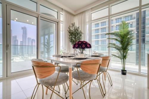 a dining room with a table and chairs and large windows at Sunrise Bay, Emaar Beachfront Dubai Harbour - Mint Stay in Dubai