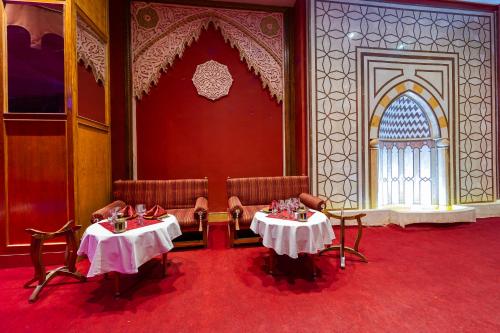 two tables in a room with chairs and a window at The Makadi Spa Hotel - Couples Only 18 Years Plus in Hurghada