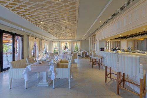 een restaurant met witte tafels en stoelen en een bar bij The Makadi Spa Hotel - Couples Only 18 Years Plus in Hurghada