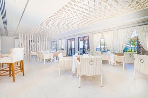 a dining room with white tables and white chairs at The Makadi Spa Hotel - Couples Only 18 Years Plus in Hurghada