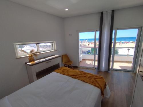 a bedroom with a bed and a view of the ocean at T2 - Praia Pescadores Frente Mar - Casas & Papéis in Armação de Pêra