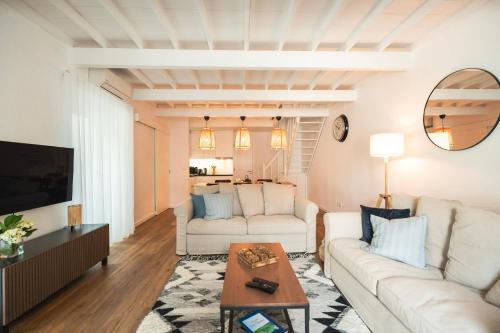 una sala de estar con 2 sofás blancos y una mesa. en Azores Green Villas en Ponta Delgada