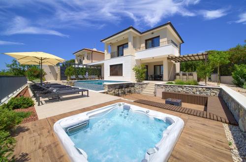 a backyard with a hot tub in front of a house at Luxury Villas LORD and LADY in Pinezici