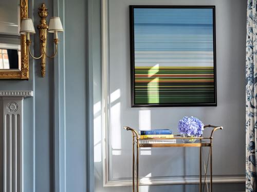 a hallway with a table with a vase of flowers at The Dorchester - Dorchester Collection in London