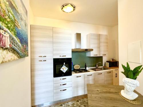 una cucina con armadi bianchi e lavandino di Antica dimora Villa Tatti-Tallacchini a Comerio