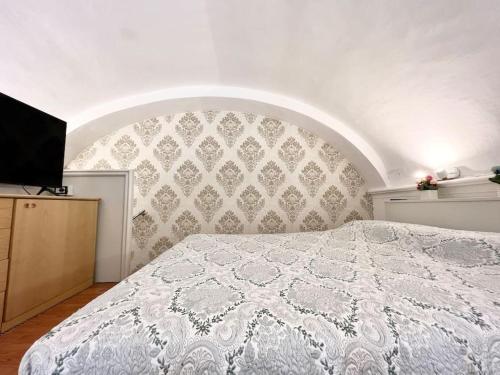 a bedroom with a white bed with a wall at Antica dimora Villa Tatti-Tallacchini in Comerio