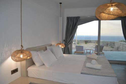 Erimo Vip في Vourvoúlos: غرفة نوم مع سرير وإطلالة على المحيط