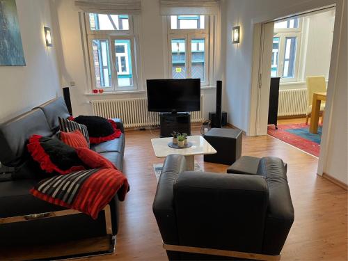 a living room with two couches and a tv at Altstadtapartments in Wernigerode
