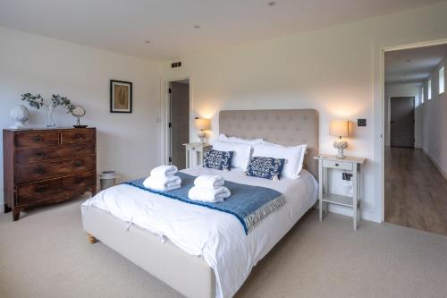 a bedroom with a large bed with towels on it at Home Reach in Aldeburgh