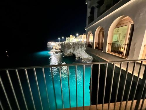 a view of the water from a balcony at night at Dimora Favale Guglielmi in Polignano a Mare