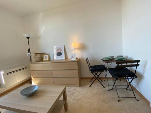 - un salon avec une table, une table et des chaises dans l'établissement Marion - La Maison Racine 3 -Charmant studio au cœur du CV, à Avignon