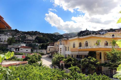 a view of a town with a yellow building at Margarita - Entire house with 4 bedrooms and free parking in Gjirokastër