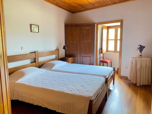 1 Schlafzimmer mit 2 Betten, einem Tisch und einem Fenster in der Unterkunft Quinta das Uchas in São Pedro do Sul