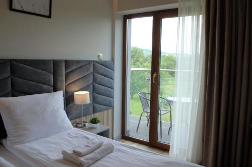 a bedroom with a bed and a sliding glass door at Villa & Gospoda Krakowska in Kobiernice
