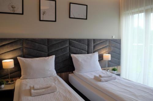 a bedroom with two beds with white sheets and two lamps at Villa & Gospoda Krakowska in Kobiernice