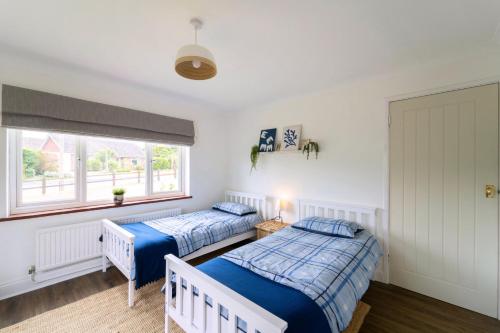 a bedroom with two beds and a window at Briar Lea in Aldeburgh