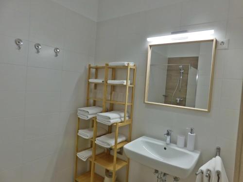 a white bathroom with a sink and a mirror at Berki Apartman in Körmend