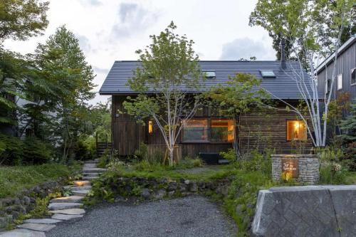 ein Zuhause mit einem Steinweg, der hinauf führt in der Unterkunft Hutte Gartenland -KAIZUKA- ヒュッテ ガーテンラント カイヅカ in Karuizawa