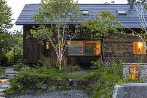 ein Haus mit Garten davor in der Unterkunft Hutte Gartenland -KAIZUKA- ヒュッテ ガーテンラント カイヅカ in Karuizawa