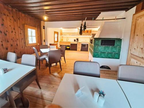 une salle à manger avec des tables et des chaises ainsi qu'une cuisine dans l'établissement Ferienhof Holzmeister, à Sankt Jakob in Haus