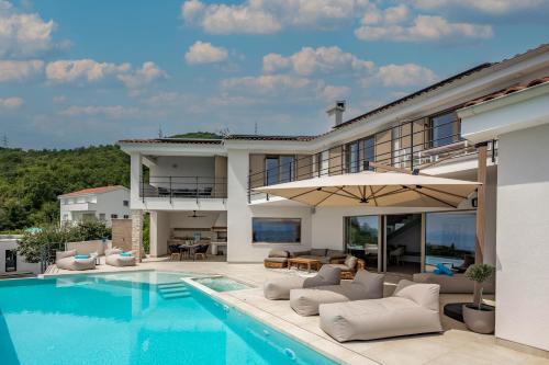 een villa met een zwembad en een huis bij Luxury Villa Dana Indoor Pool and Sauna - Happy Rentals in Ičići