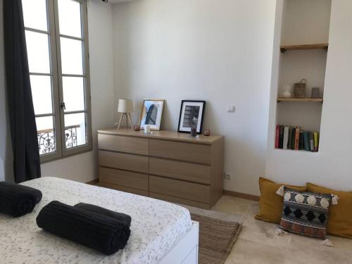 ein Schlafzimmer mit einem Bett, einer Kommode und einem Fenster in der Unterkunft La Maison Racine 4 - Cocon en plein centre ville in Avignon