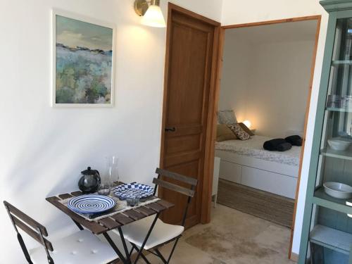 Cette petite chambre comprend une table et un lit. dans l'établissement Maya - La Maison Racine 4 - Cocon en plein centre ville, à Avignon