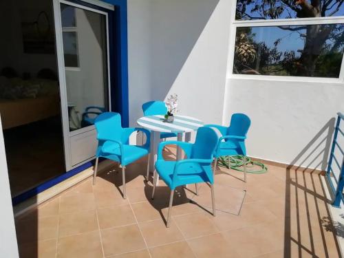 comedor con sillas azules y mesa en Brisamar, en Aljezur