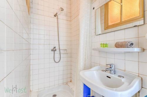 a white bathroom with a sink and a shower at Charmant et lumineux T2 centre ville au calme in Nantes