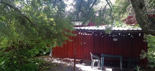 a red shed with a table and chairs next to it at Atpūtas vieta Buki in Ventspils