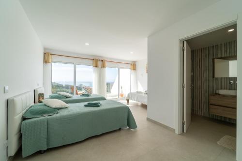 - une chambre avec 2 lits verts et une salle de bains dans l'établissement Vale Terra Mar, à Aljezur