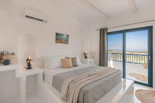 een witte slaapkamer met een bed en een balkon bij Villa Camelia-Iris sunset villas in Lépedha