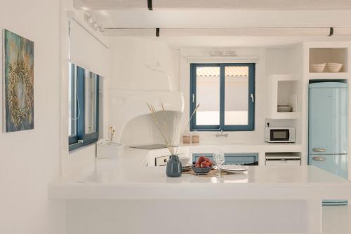 een witte keuken met een wit aanrecht bij Villa Camelia-Iris sunset villas in Lépedha