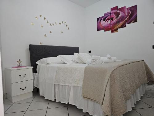 um quarto com uma cama com lençóis brancos e uma mesa de cabeceira em LA Giulia em Capri