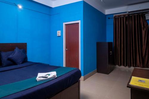 Un dormitorio azul con una cama con una toalla. en Shree Krishna GH, en Guwahati