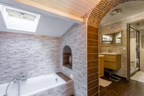 uma casa de banho com uma banheira e um lavatório em Vila avec, piscine, tennis. em Rivaux