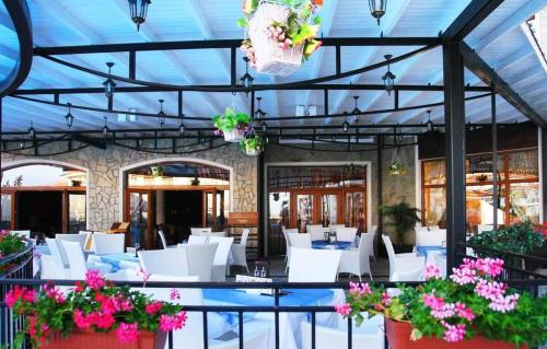 un ristorante con sedie e tavoli bianchi e fiori di Victoria Villa, 13 Merlot street, The Vineyards resort, Aheloy, Pomorie. a Burgas