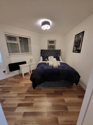 a bedroom with a large bed and a wooden floor at Lovely 2-Bed Apartment in Grays in South Ockendon