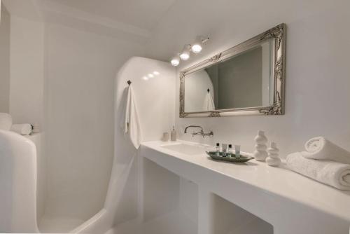 a white bathroom with a sink and a mirror at Villa Giasemi-Iris sunset villas in Lépedha