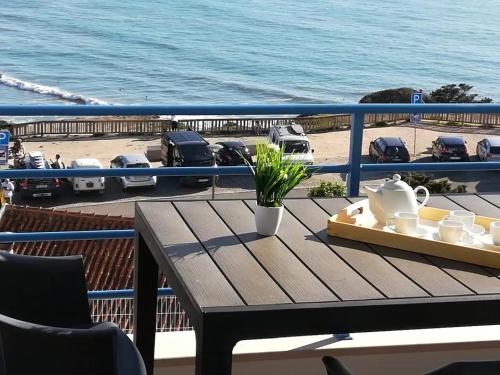 a table on a balcony with a view of the ocean at Pôr do Sol in Aljezur