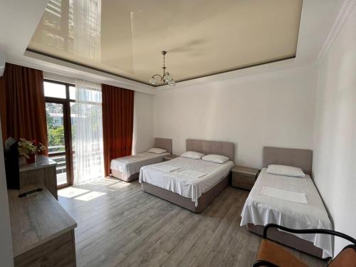 a bedroom with two beds and a large window at GARDEN IN GONIO MATATA MOTSIKULIS 58 in Batumi