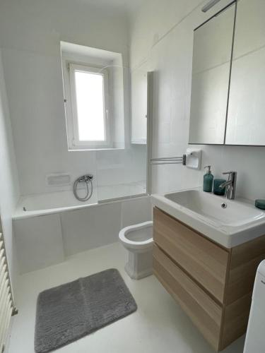 a white bathroom with a sink and a toilet at Nona's view with balcony in Rijeka