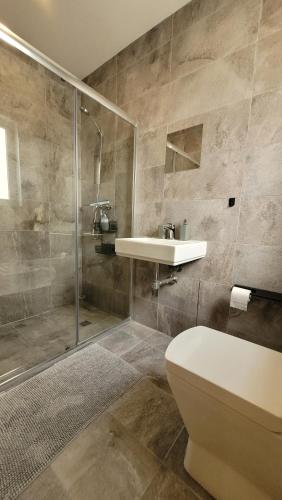 y baño con aseo, lavabo y ducha. en Stylish - Modern - Large Terrace - 2 Bed - 200 M From Sea - Fully Air Con en St Paul's Bay