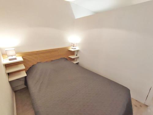 een kamer met een groot bed in een kamer met 2 verlichting bij Le Sentein, T2, centre, parking, jardin, 2 personnes in Luchon