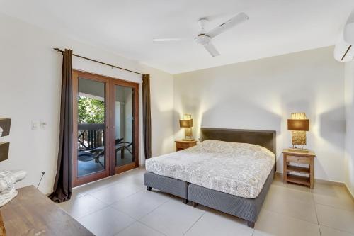 um quarto com uma cama e uma porta de vidro deslizante em Bonaire Apartment em Kralendijk