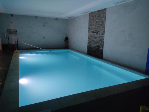 a swimming pool with blue lighting in a room at Hostel S. Miguel FitNCare in Guarda
