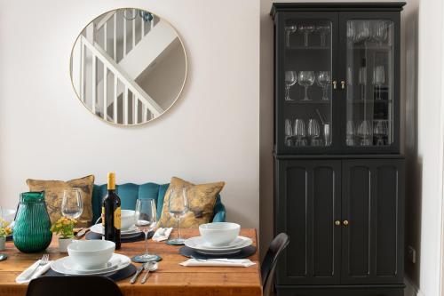 a dining room table with a black cabinet and a mirror at Nythfa in Llanrwst