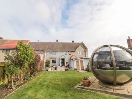 a large metal circle sculpture in the yard of a house at Coast Cottage in Bamburgh